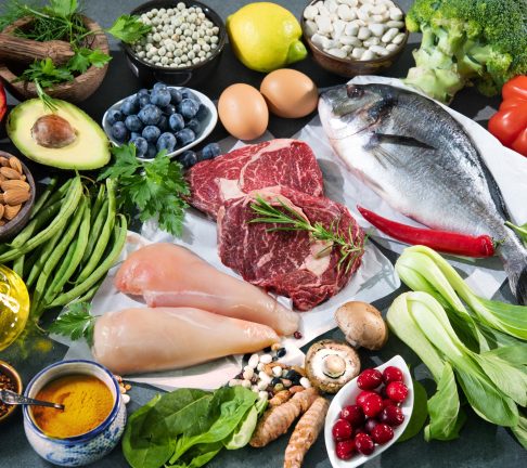 Balanced diet food background. Selection of various paleo diet products for healthy nutrition. Superfoods, meat, fish, legumes, nuts, seeds, greens and vegetables